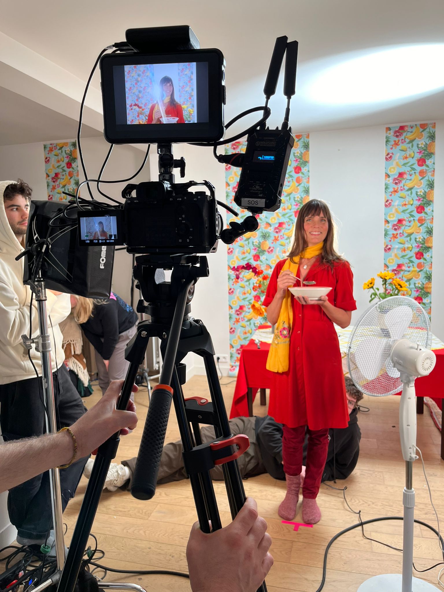 Un tournage en intérieur, avec caméra et équipe devant une comédienne